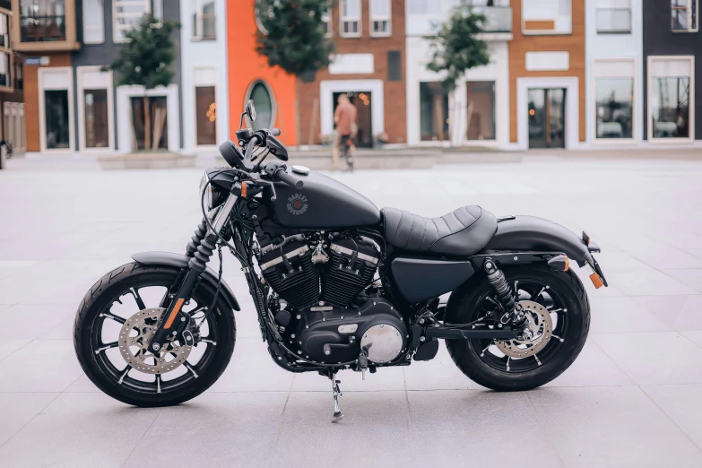 a motorcycle parked on concrete in front of an apartment complex