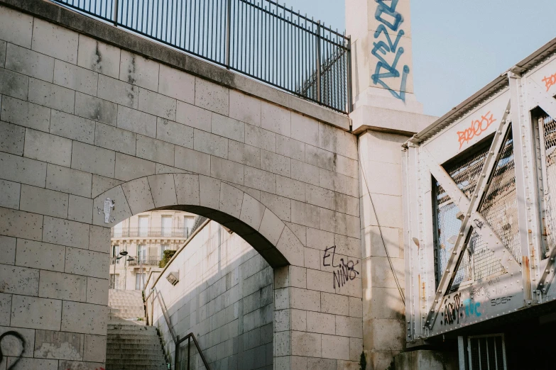 an alley way with concrete walls and iron railings