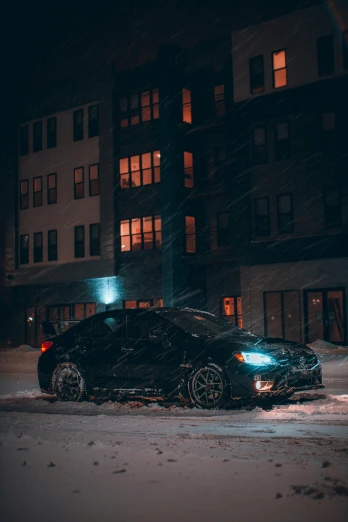 a car parked on the side of the street in snow at night