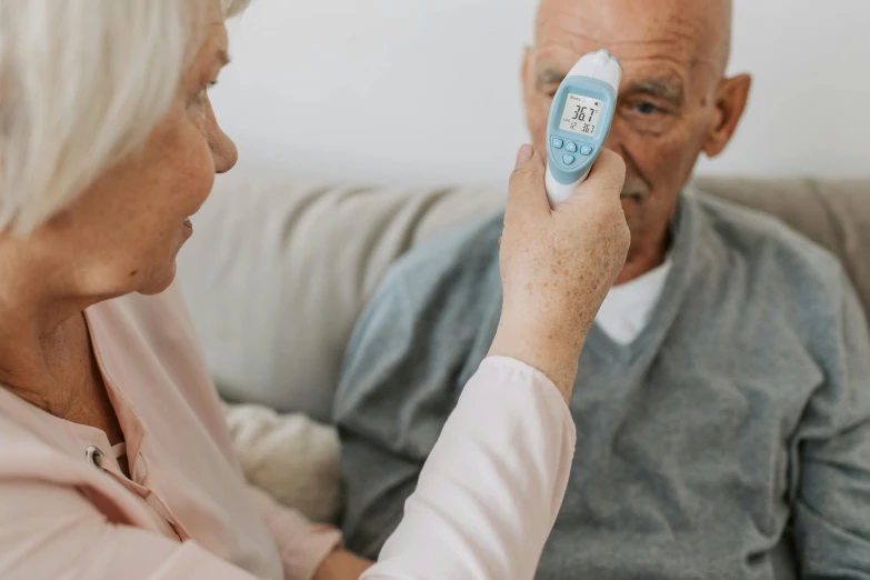 the elderly man is holding an electronic device in his hand