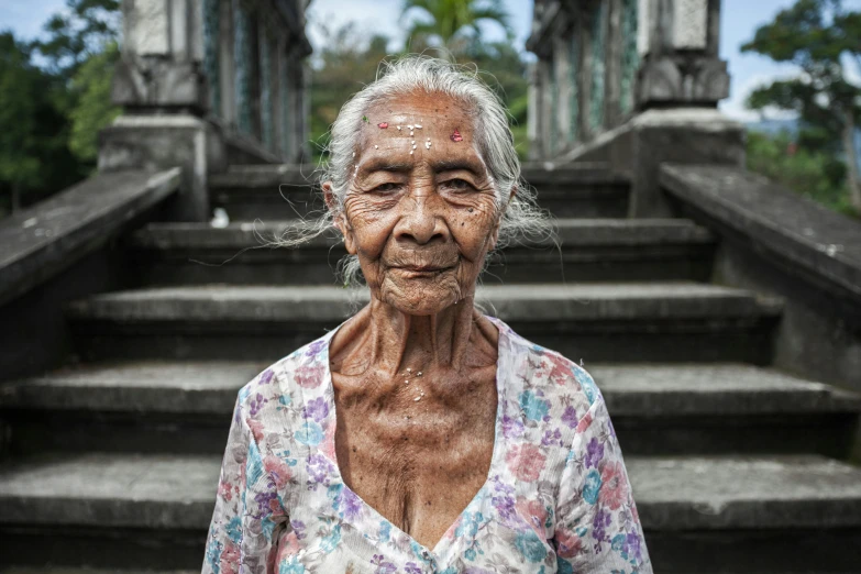 an old lady standing at the top of some stairs