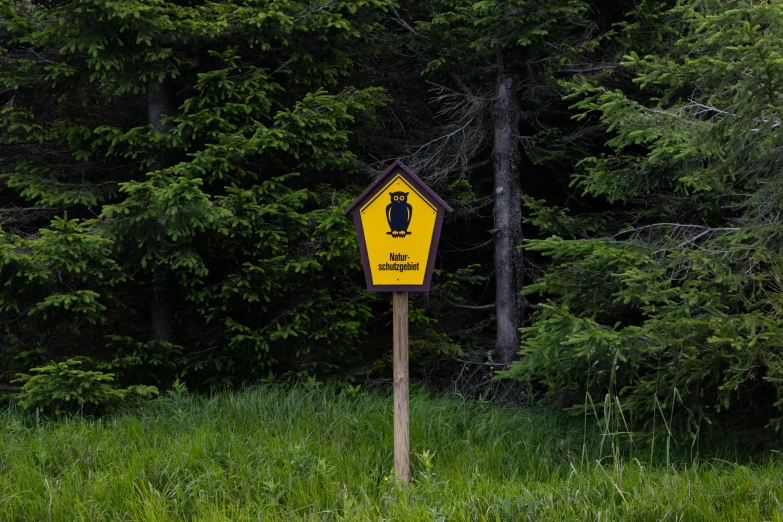 the yellow caution sign is standing in a field