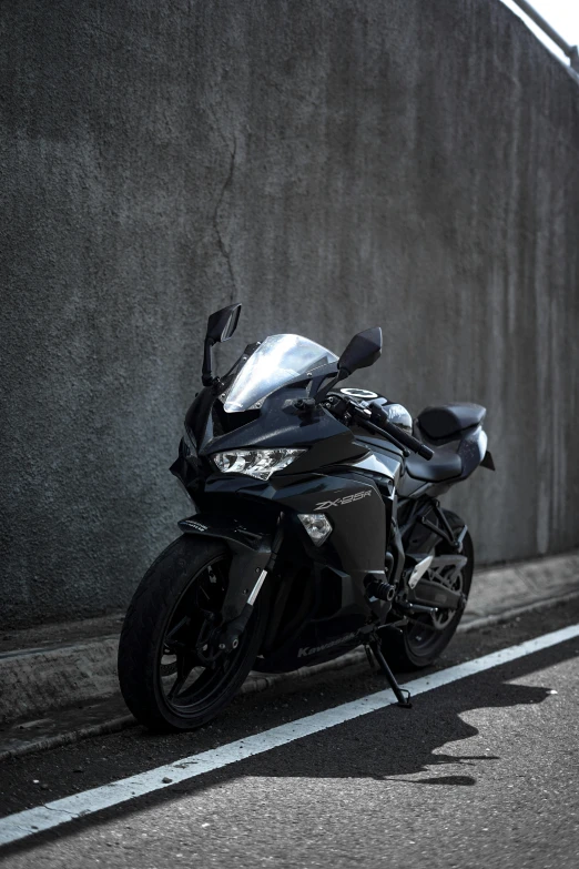 a motorcycle parked on a street near a wall