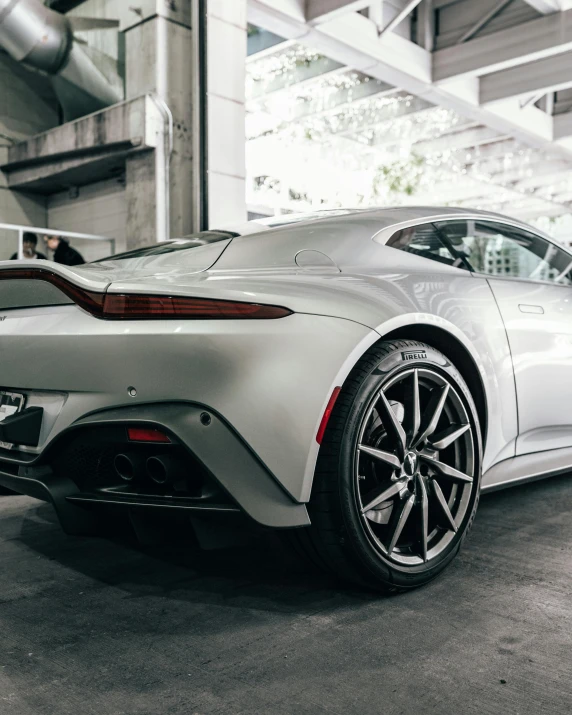 a grey sports car sits parked in a garage