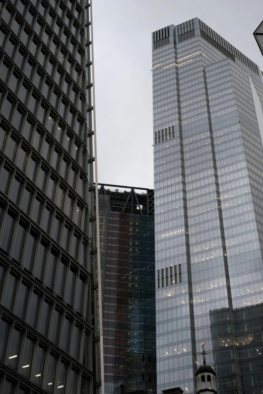 a tall glass building sitting between two other tall buildings