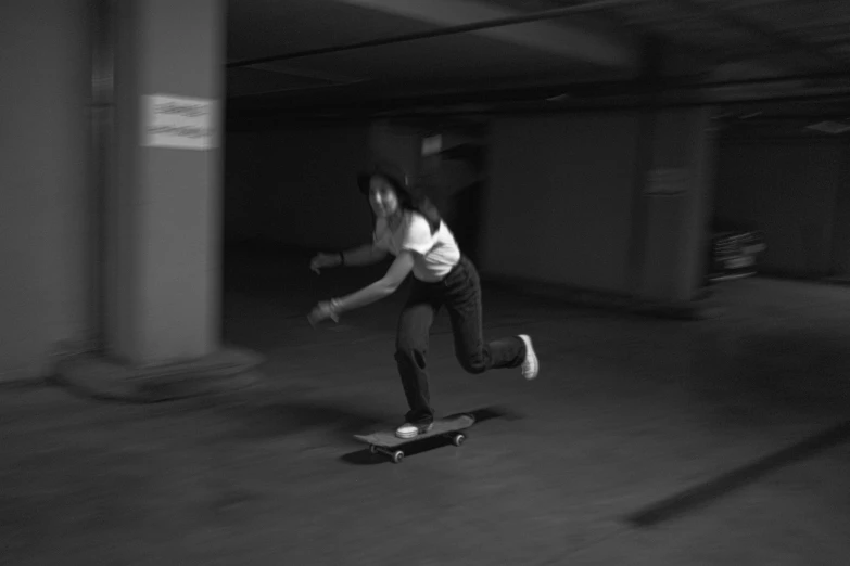 the skateboarder is doing a trick at night in a parking garage