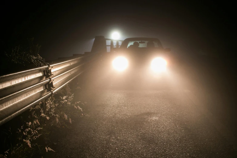 three headlights at night in a foggy area