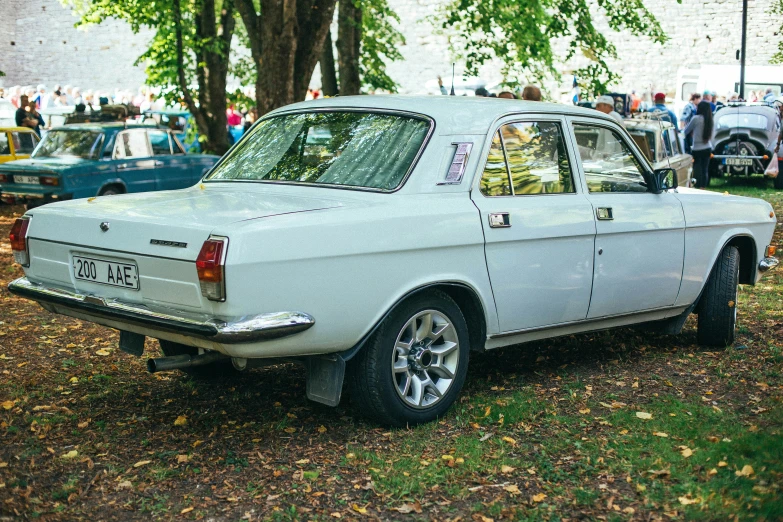 a white old car parked on the grass