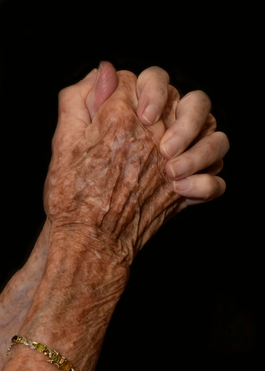 two old hands on a dark background
