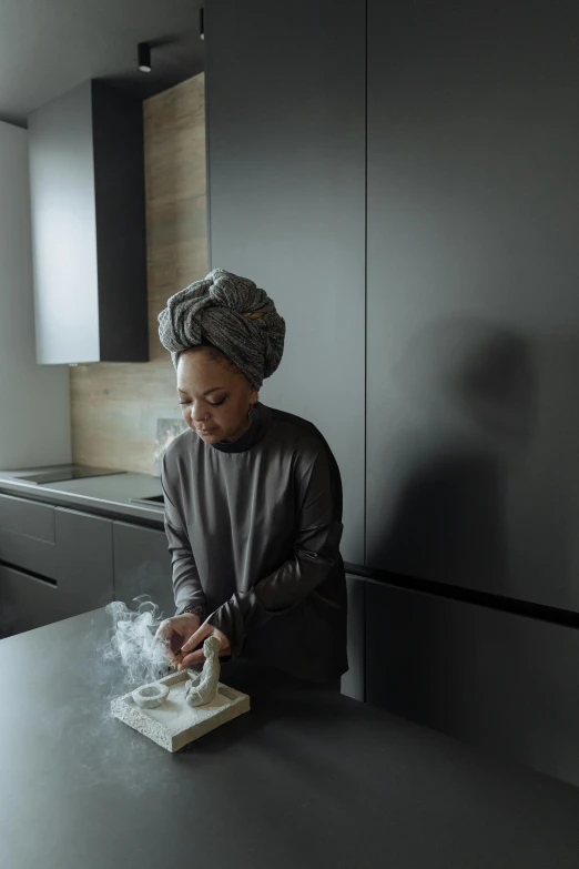 a woman making soing out of paper sitting on a counter
