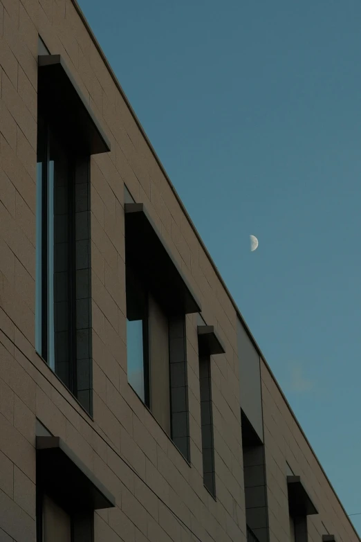 a building with windows and a crescent moon in the sky