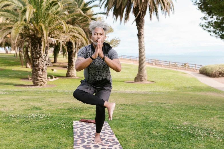 a woman doing yoga in front of palm trees