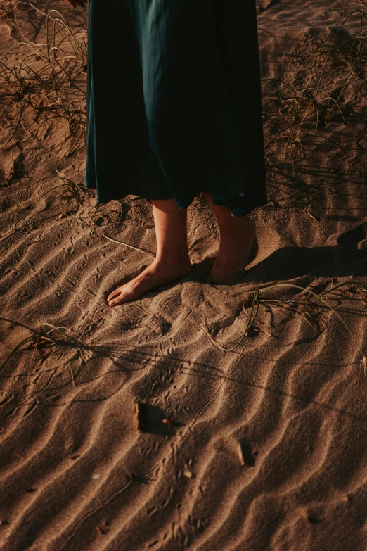 a closeup of a person walking in the sand