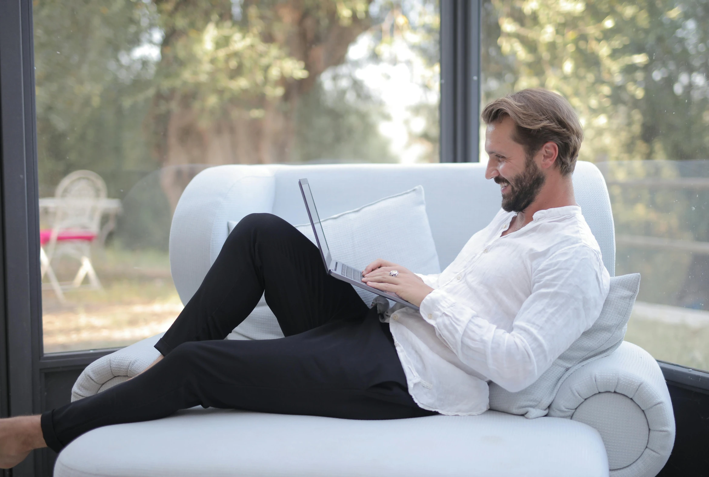 a man sitting on a couch using a laptop computer