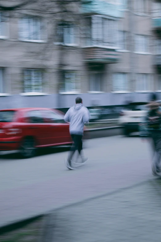 blurry pograph of people running on a sidewalk