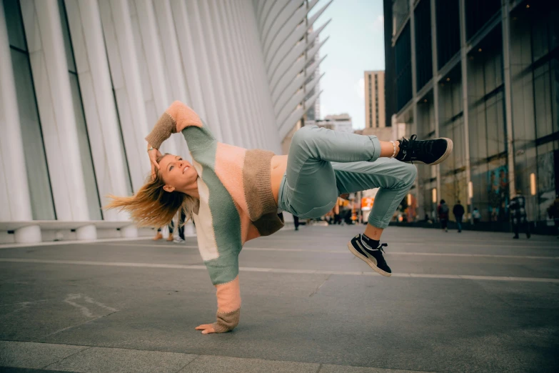 a girl is doing a handstand in the city