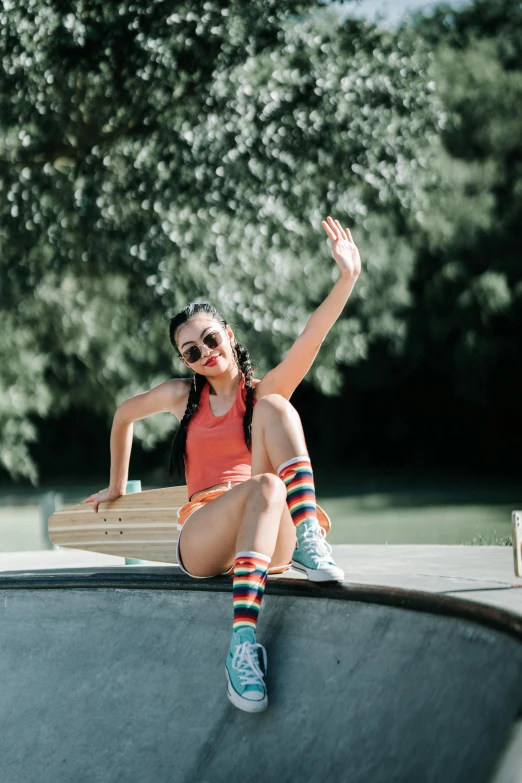 girl sitting on a ledge with her feet up in a hat and sunglasses