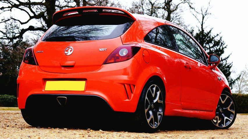 a red car parked in front of trees