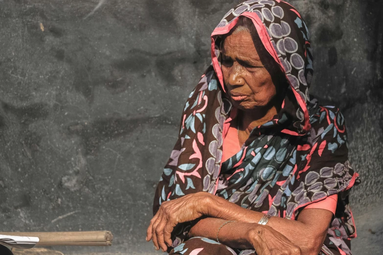 a woman sits next to a piece of metal