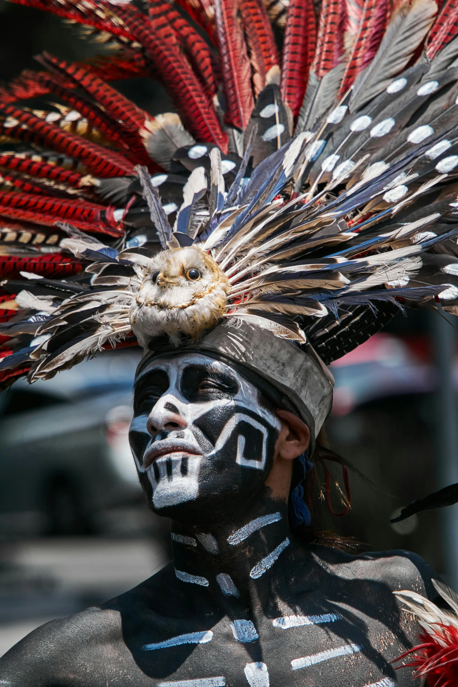 man wearing native garb and headdress in the street