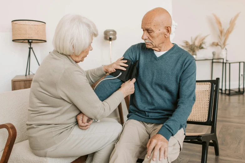 an older man getting a heartbeat check from another old lady