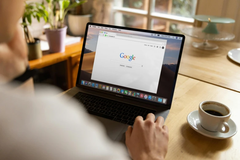 a person sits at a table and uses a laptop computer