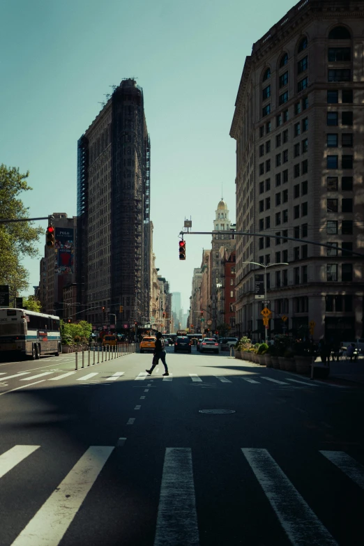 man skateboards across the street in an urban setting