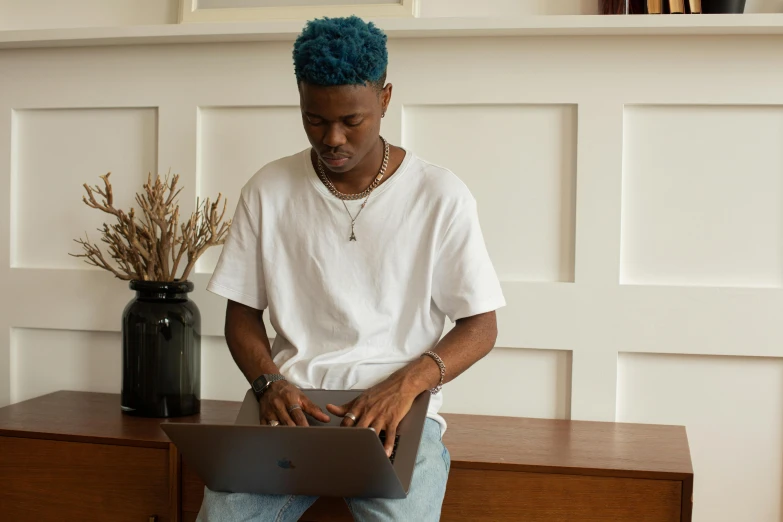 a man that is sitting down with a laptop