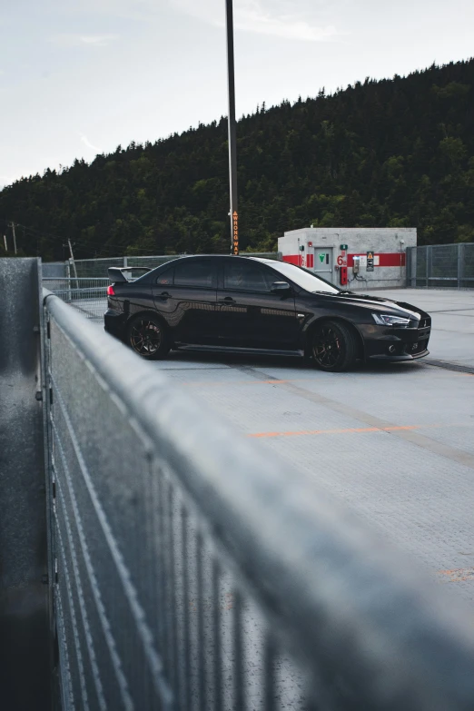 black bmw with red accent on its hood sitting next to another car