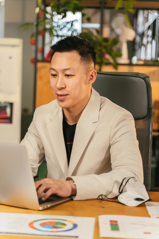 a man in a beige suit is working on his computer