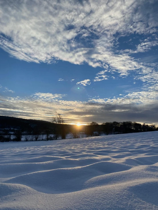 the sun is coming up behind a snowy mountain