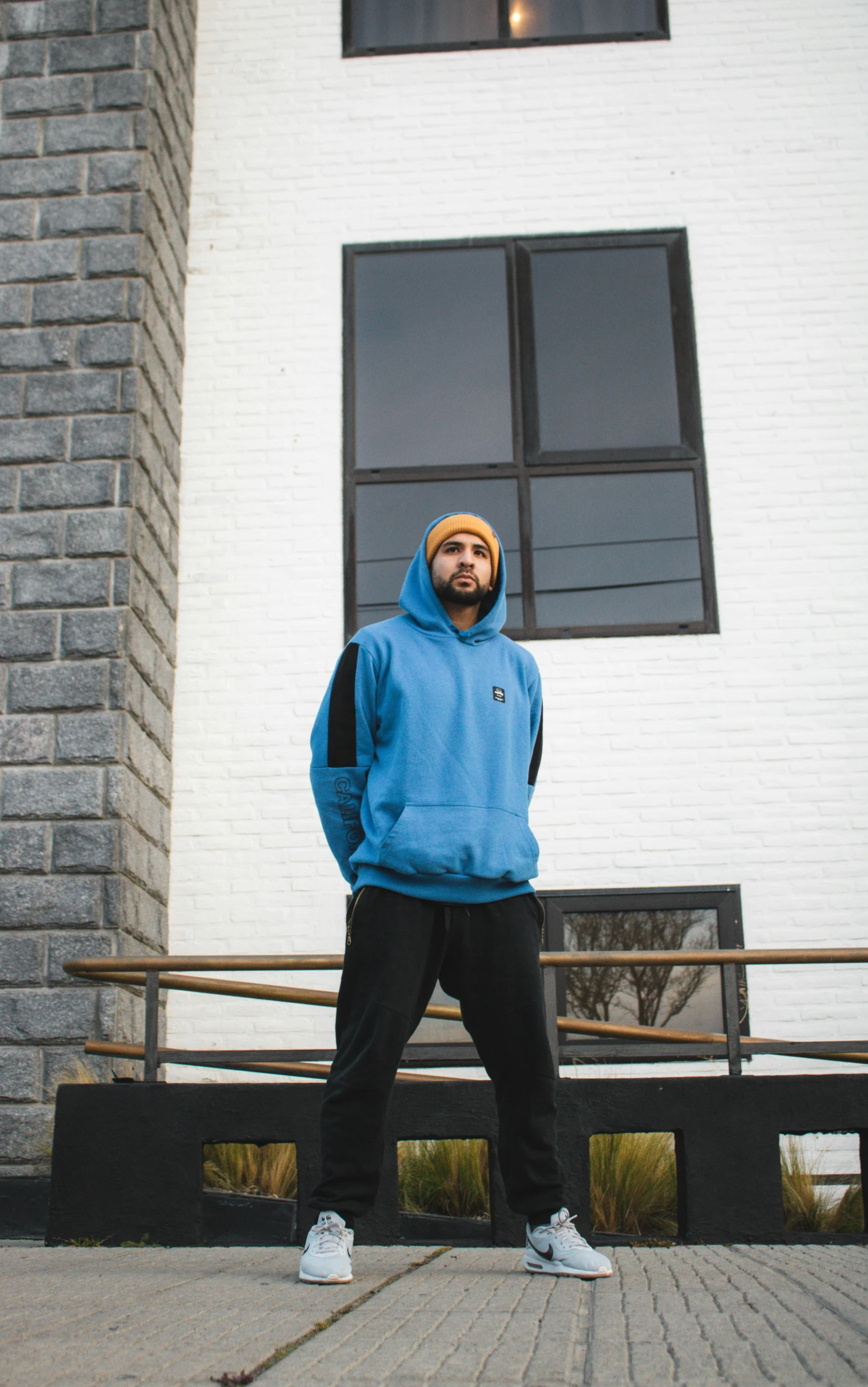 a person with a backpack and boots standing in front of a building