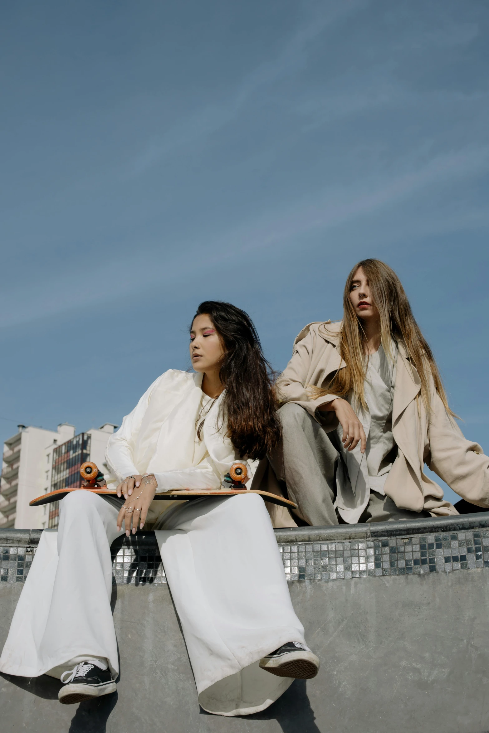 two female skateboarders sitting down near each other