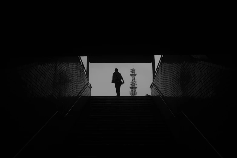 a person standing on top of a dark set of stairs