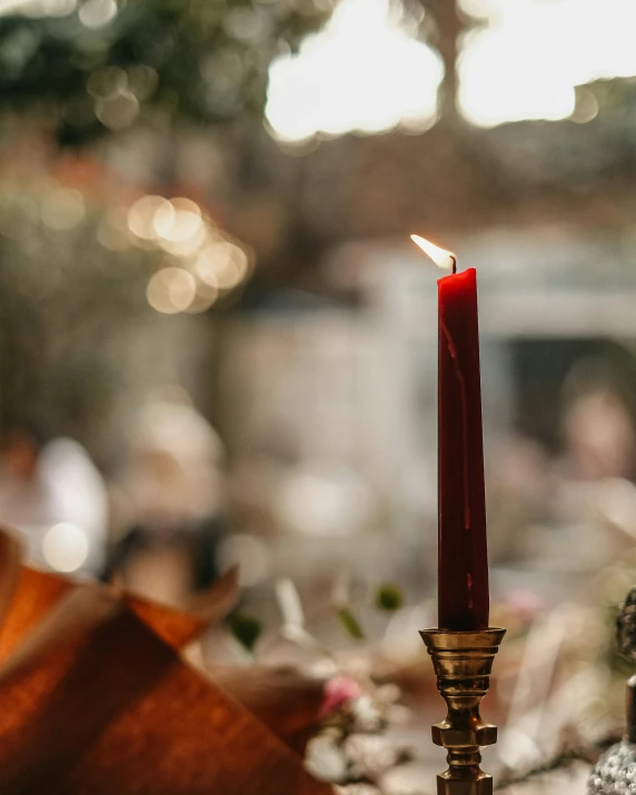 a candle lit up in a candle holder on the table