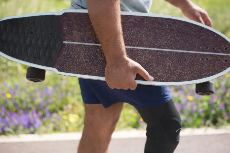 a man in shorts holding onto his skateboard