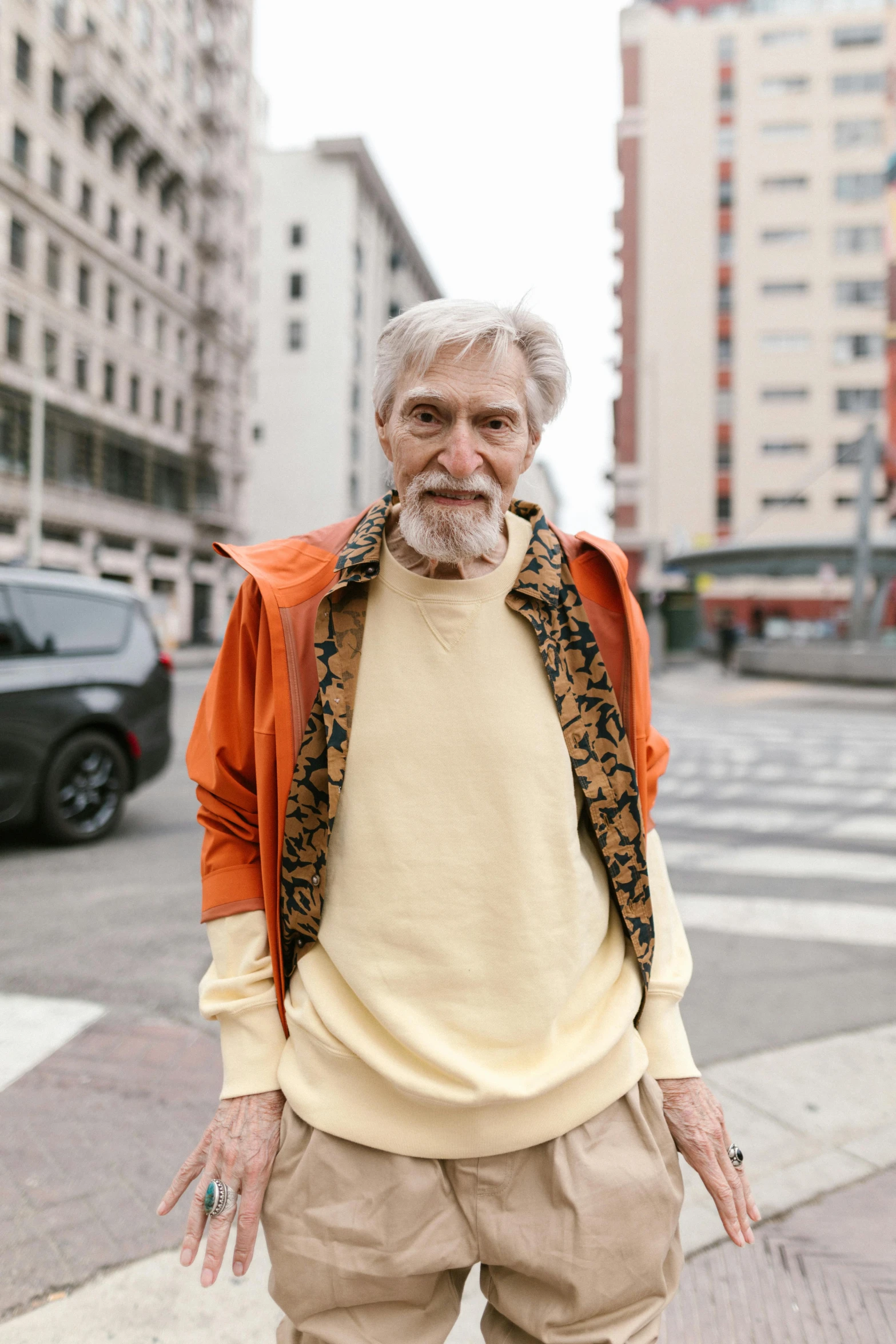 an older man standing on a sidewalk near a street