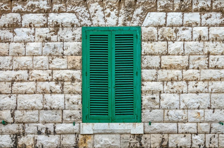 the wall has a window that is green