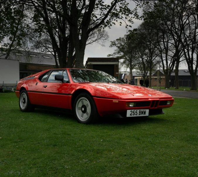 a car is parked in the grass next to a large tree