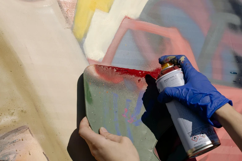 someone painting soing with red, green, yellow and purple spray