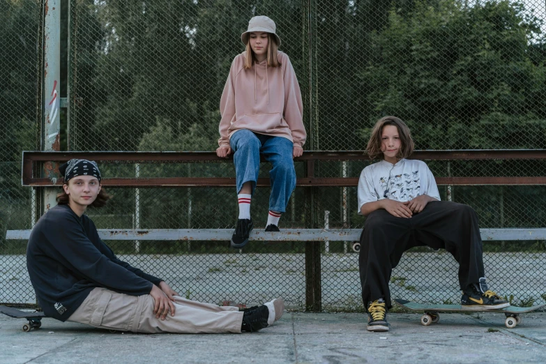 three s sitting on benches with skateboards at one end