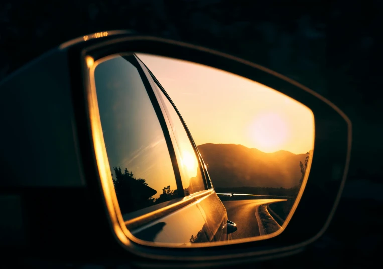 a rearview mirror with a reflection of the sun