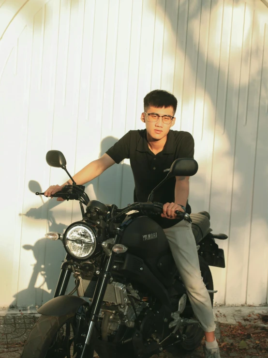 a man is sitting on a motorcycle posing for the camera