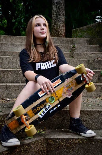 a girl sitting on a staircase with her skateboard