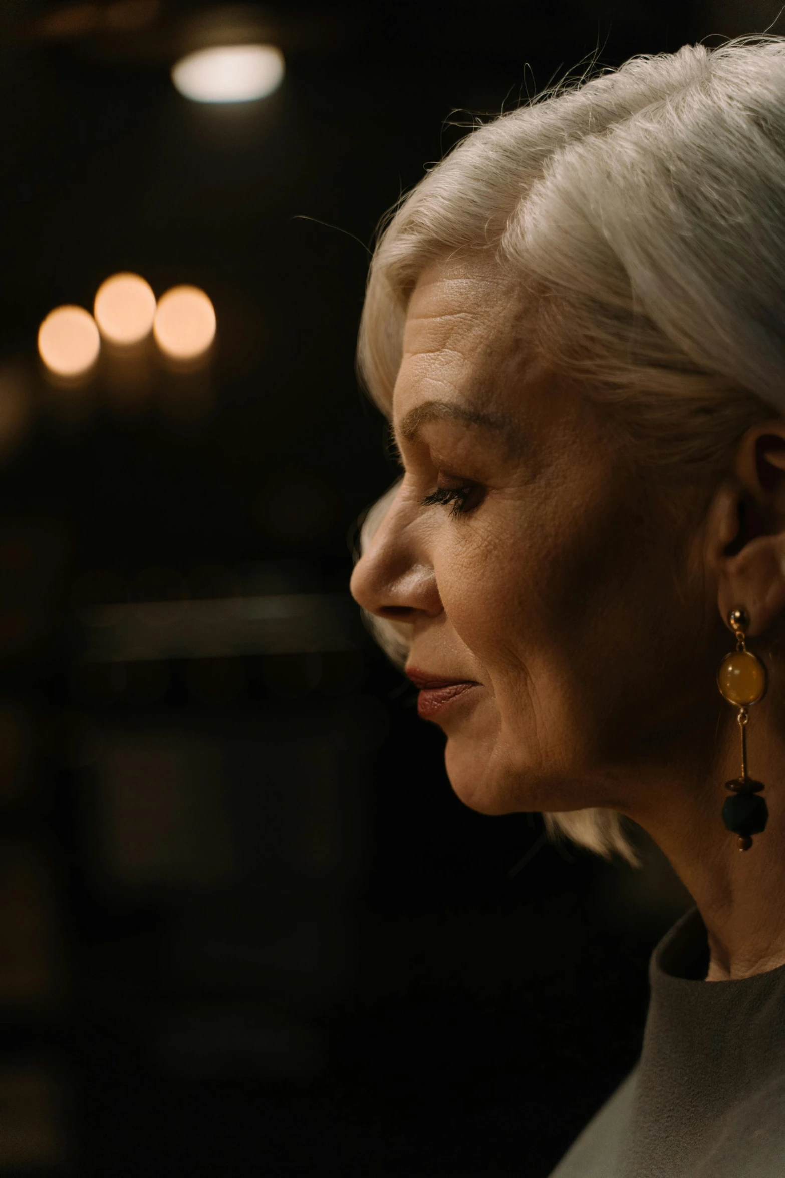 a woman with silver hair and some sort of earrings