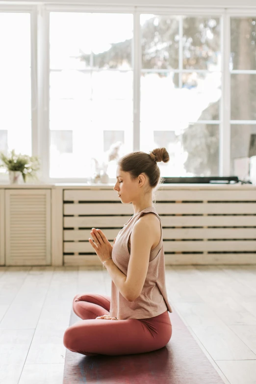 a girl is sitting on the floor in a yoga position