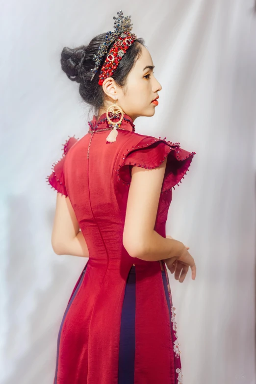 young lady with bun in red dress against white background