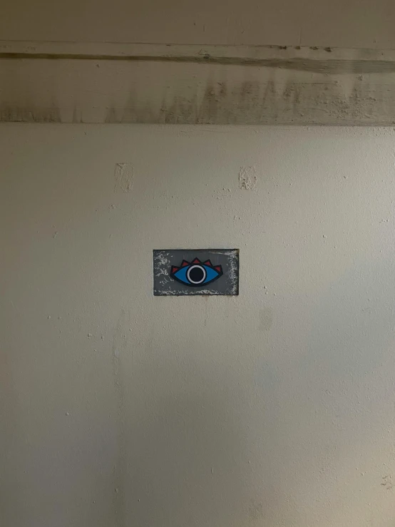 a blue evil eye painted on the side of a wall