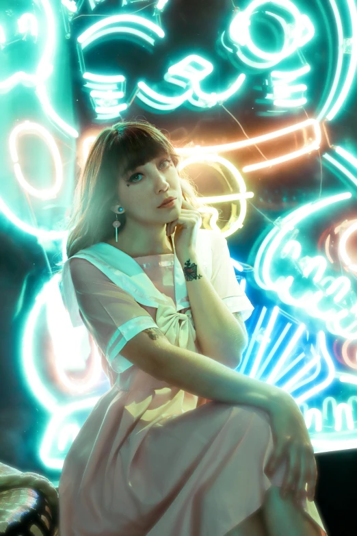 a woman sitting on a bench in front of neon signs