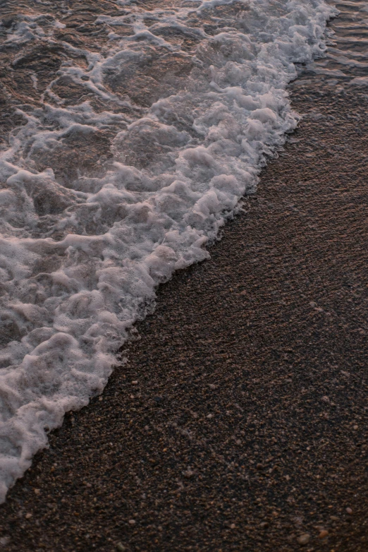 an ocean wave is rolling in from the sand